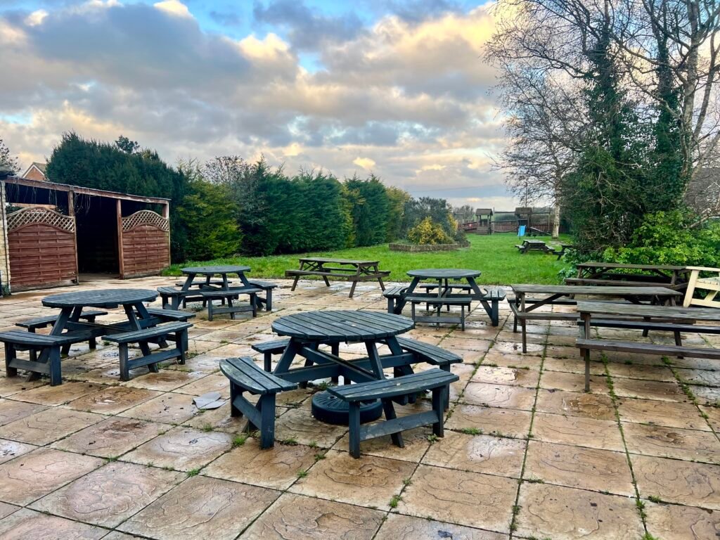 Garden view of The Chequers, with benches on the patio.
